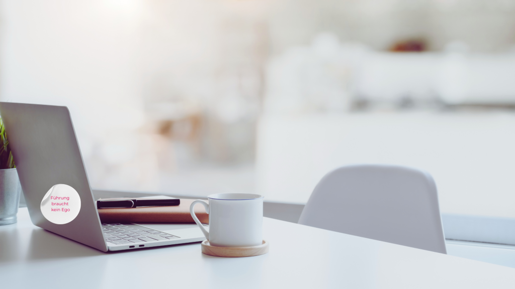 Laptop auf einem Schreibtisch mit einer Tasse Kaffee daneben