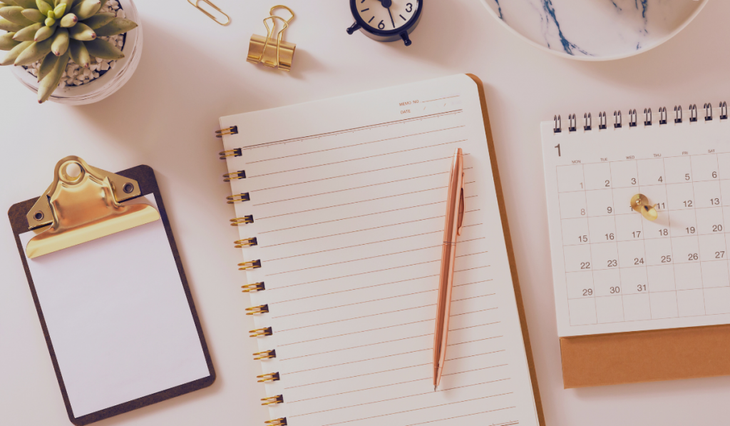 Schreibtisch mit Heft, Kalender und Kaffeetasse